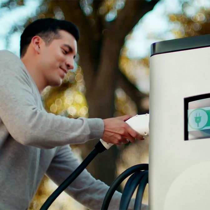 A man plugging into an electric charging station.