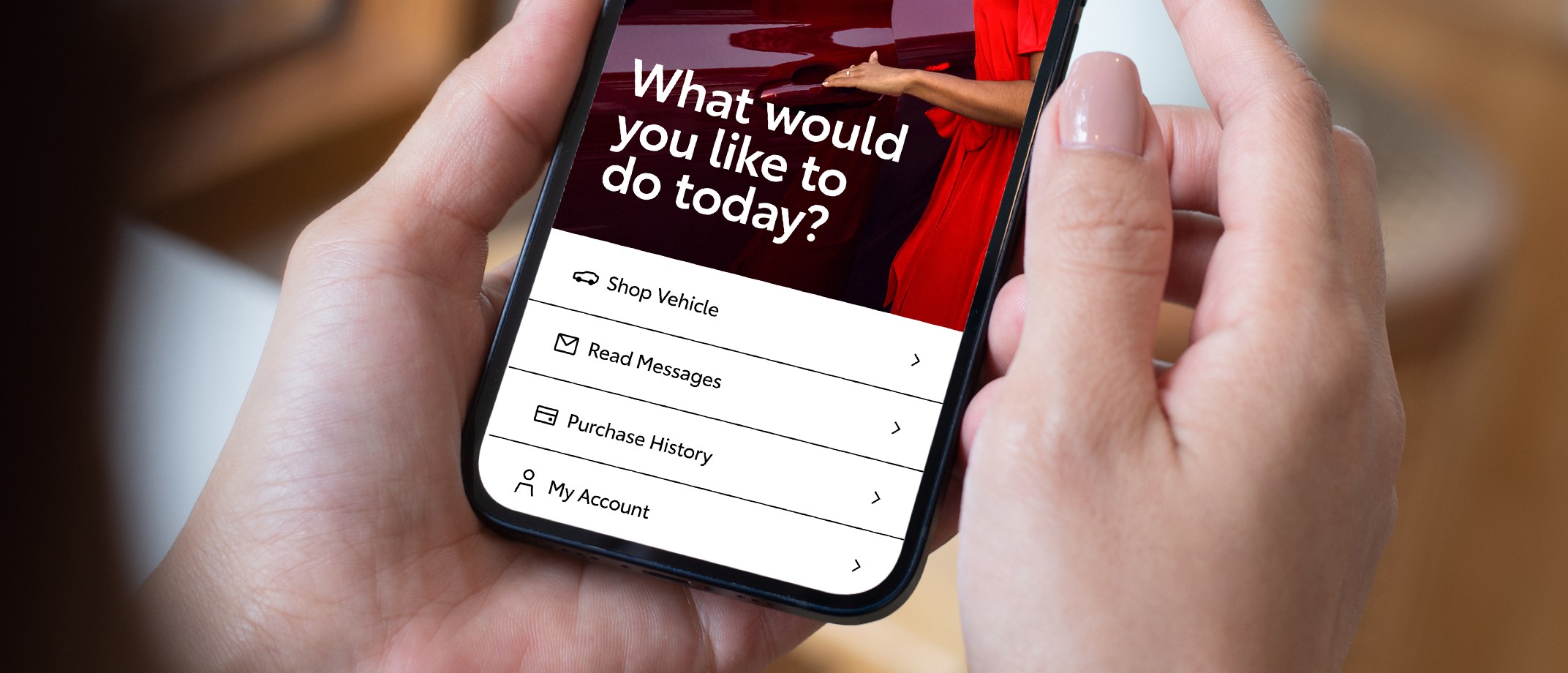 A hand holding a phone with a screen that reads “What would you like to do today?” Below are small icons next to items in a dropdown menu.