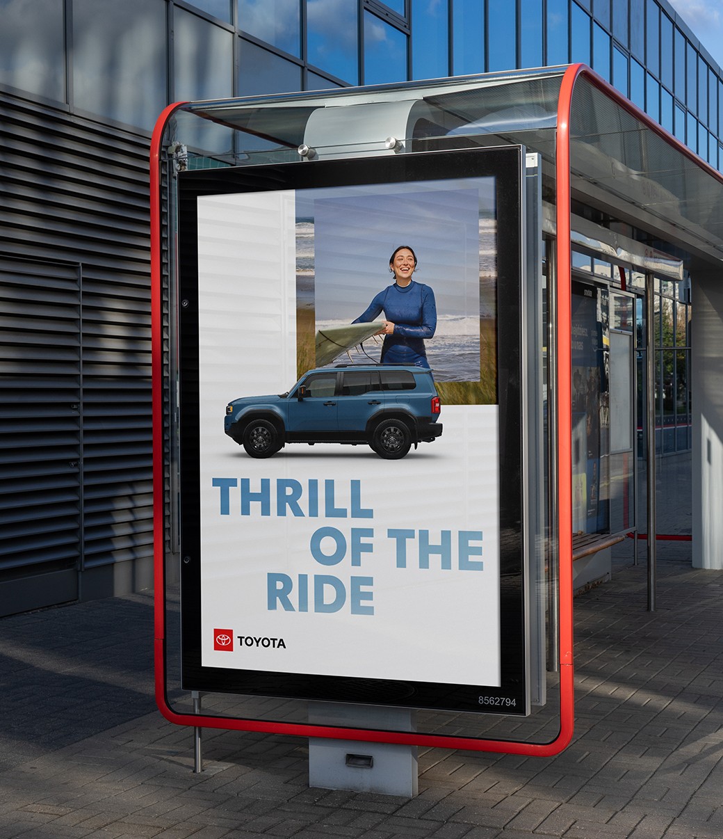 A slider divides an image of an out-of-home board. The slider moves back and forth to show a layout grid of the ad and then the finished ad with imagery.