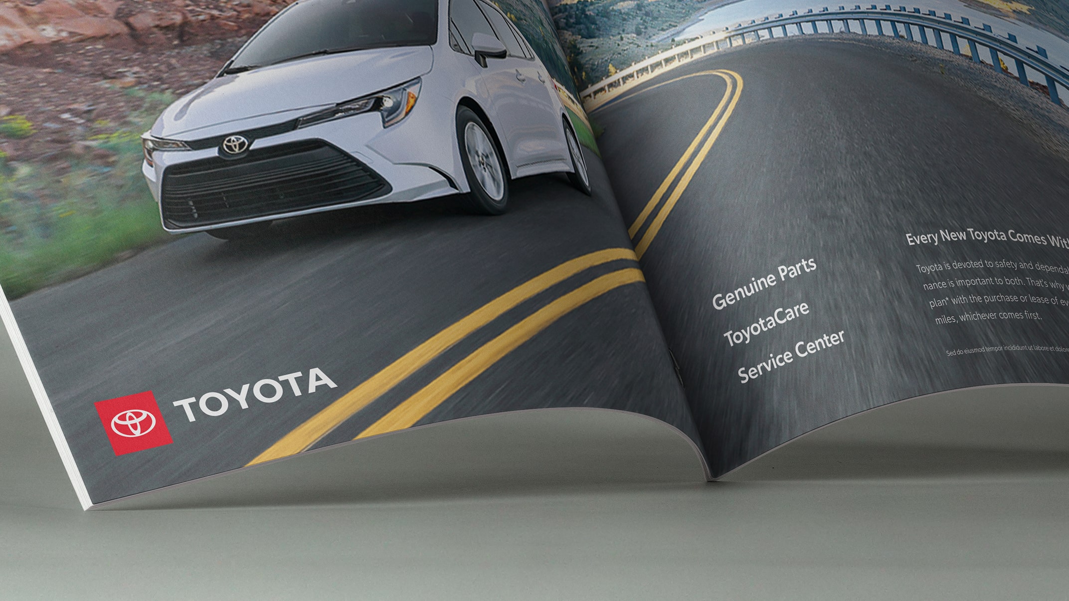 The bottom pages of a magazine show a vehicle driving along a highway. To the left is the Toyota logo. To the right of the page, the text reads “Genuine Parts, ToyotaCare, Service Center.”