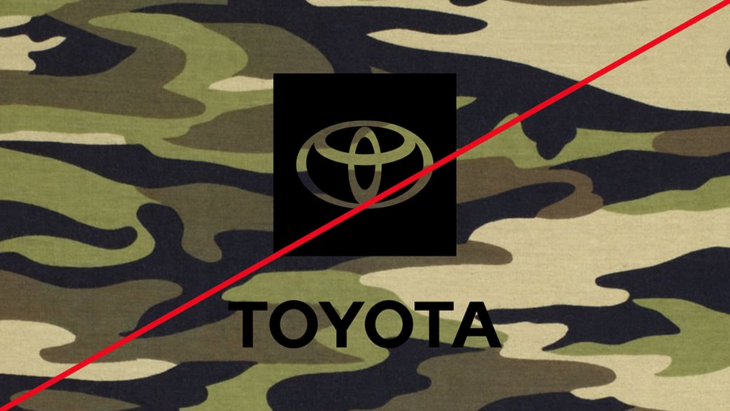 A black single-color Toyota logo on a camo-patterned background showing incorrect usage.