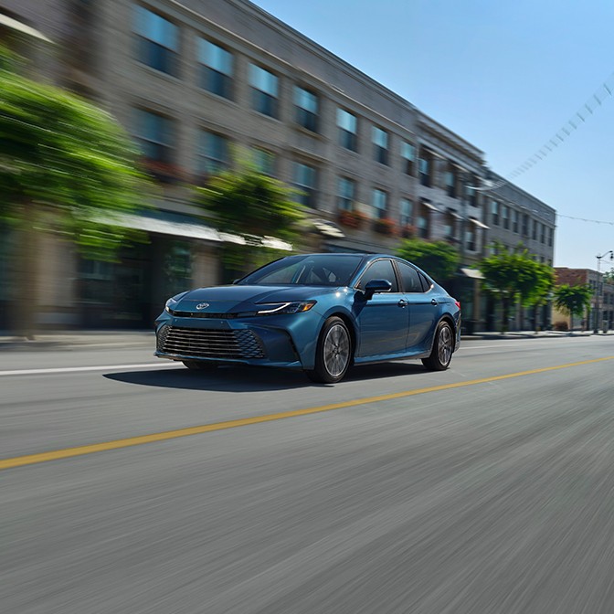  A car driving on a road with a blurred background.