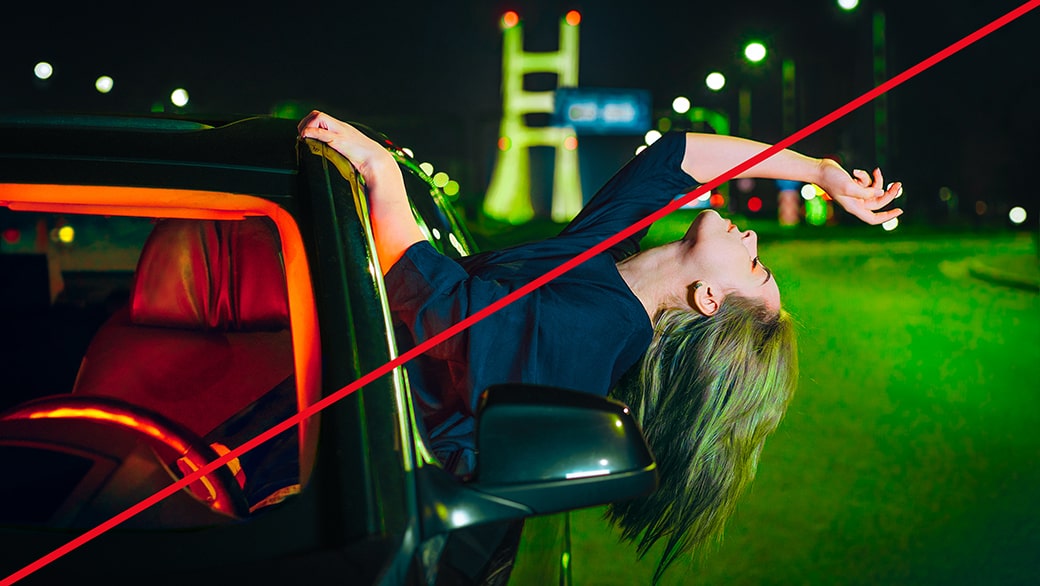An image of a woman hanging out a vehicle with green-and-red fluorescent lighting, representing incorrect lighting.