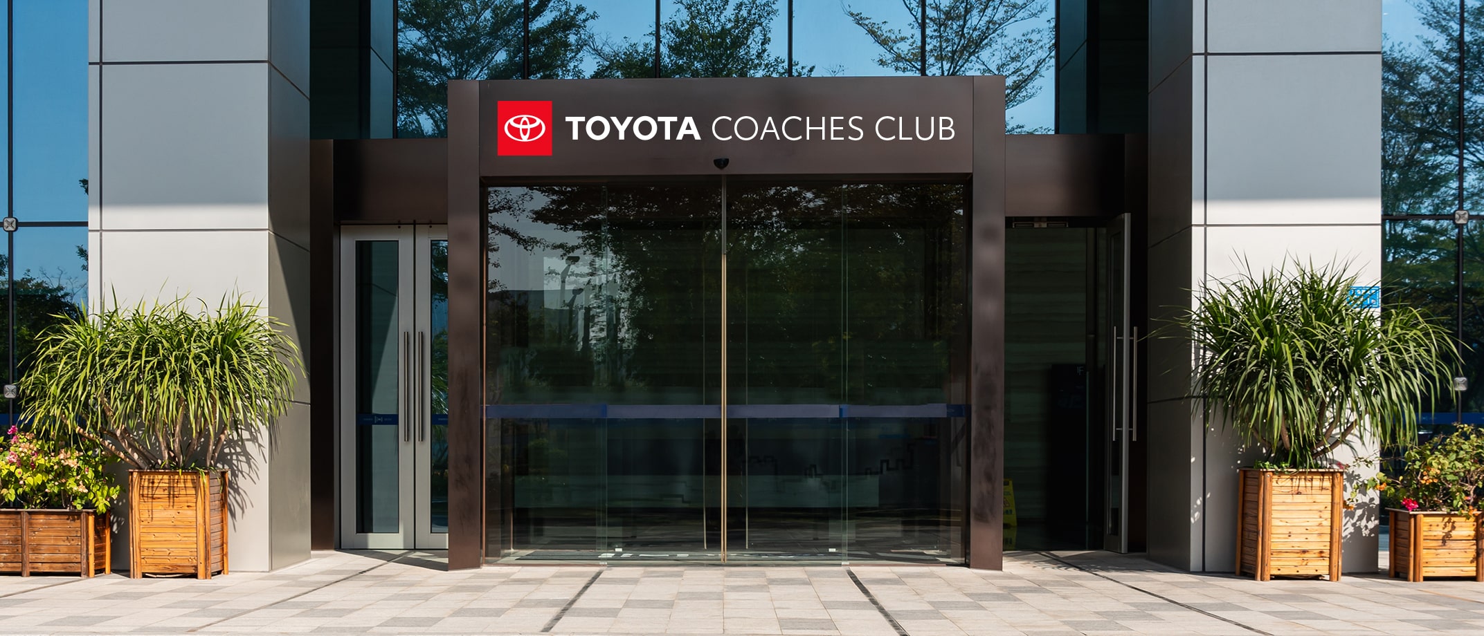 Toyota sponsorship signage example on the front entrance of a modern building.