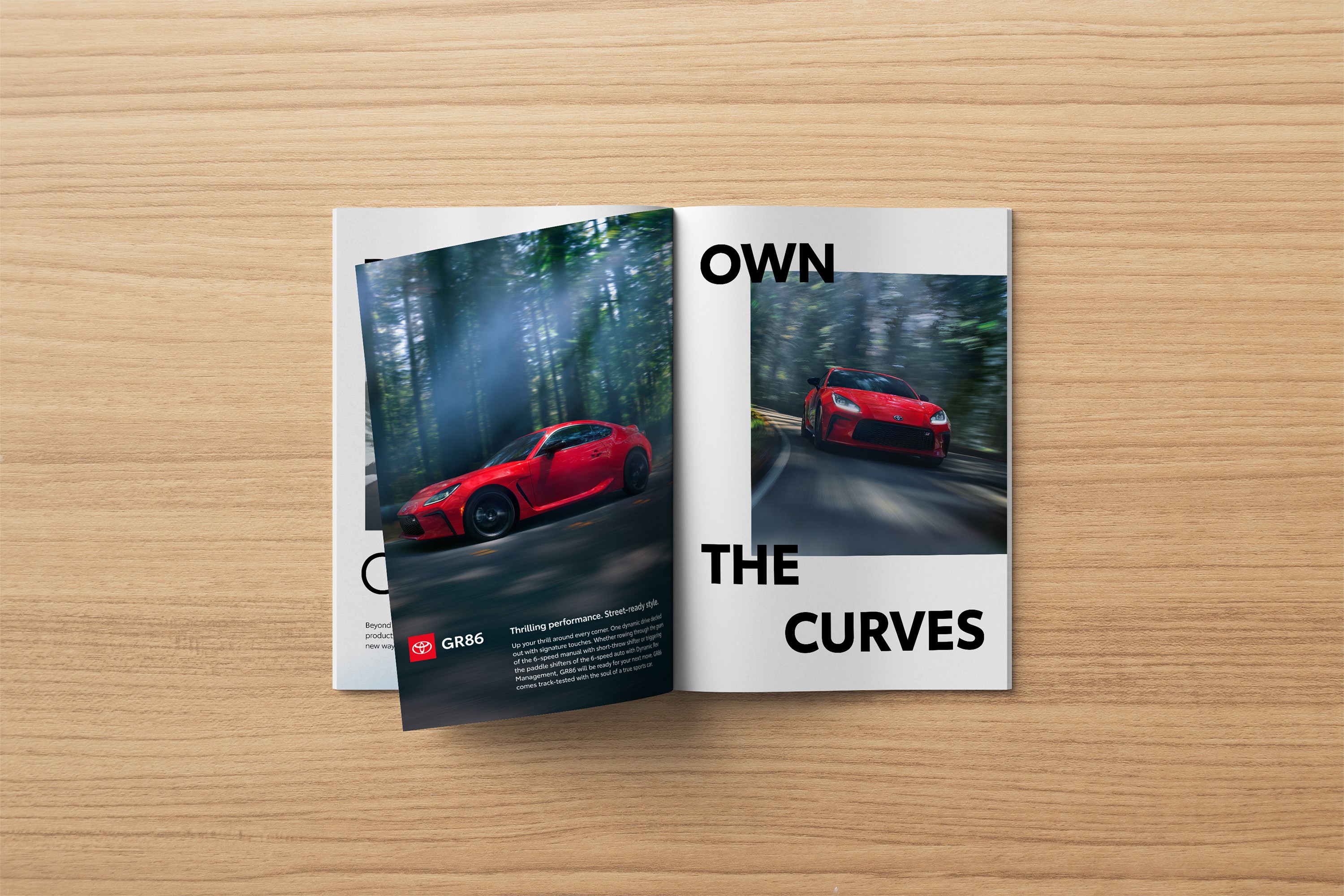 An open magazine on a wooden table displays a Toyota GR86 ad with a bold headline and imagery.