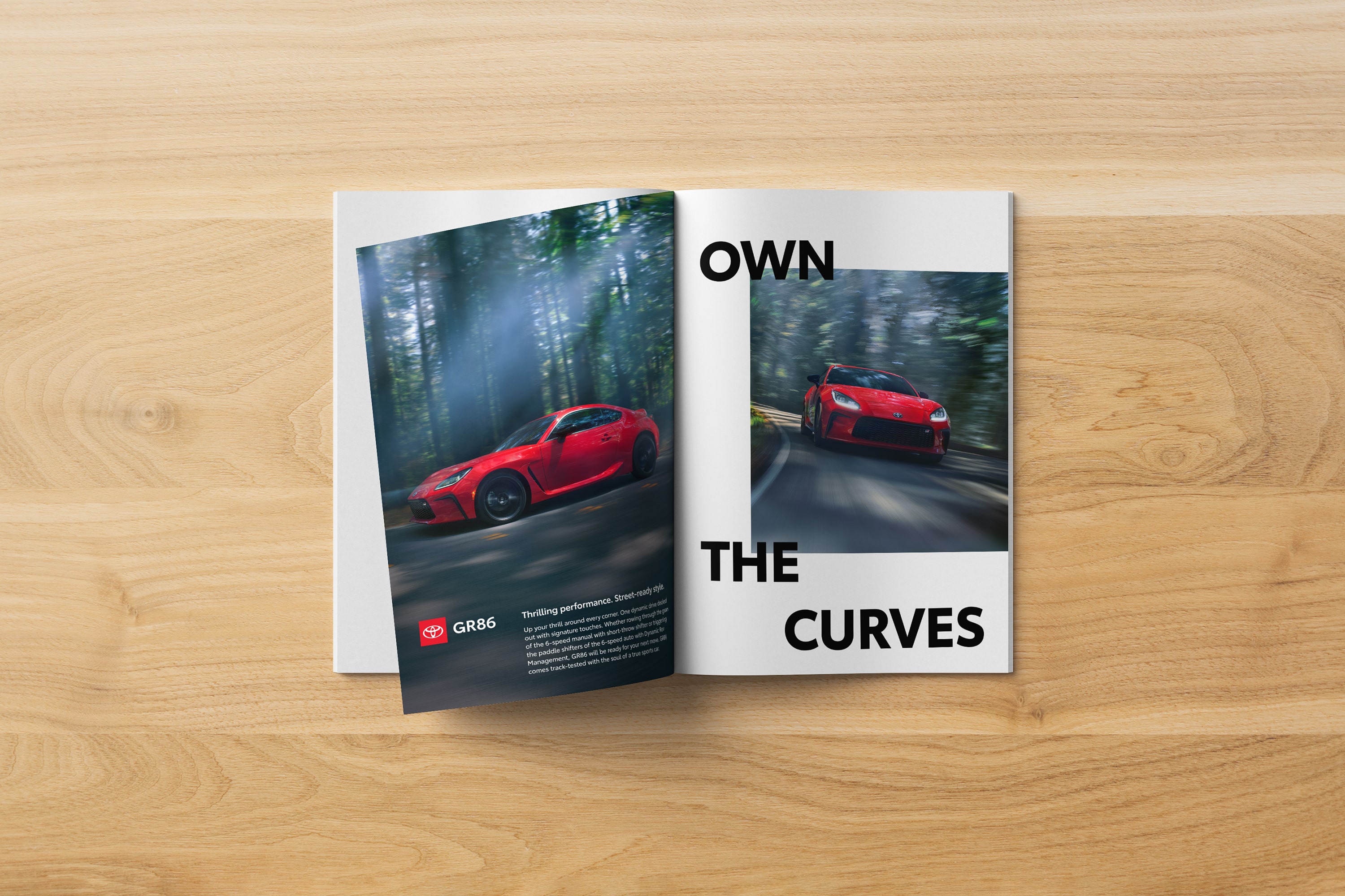 An open magazine on a wooden table displays a Toyota GR86 ad with a bold headline and imagery.