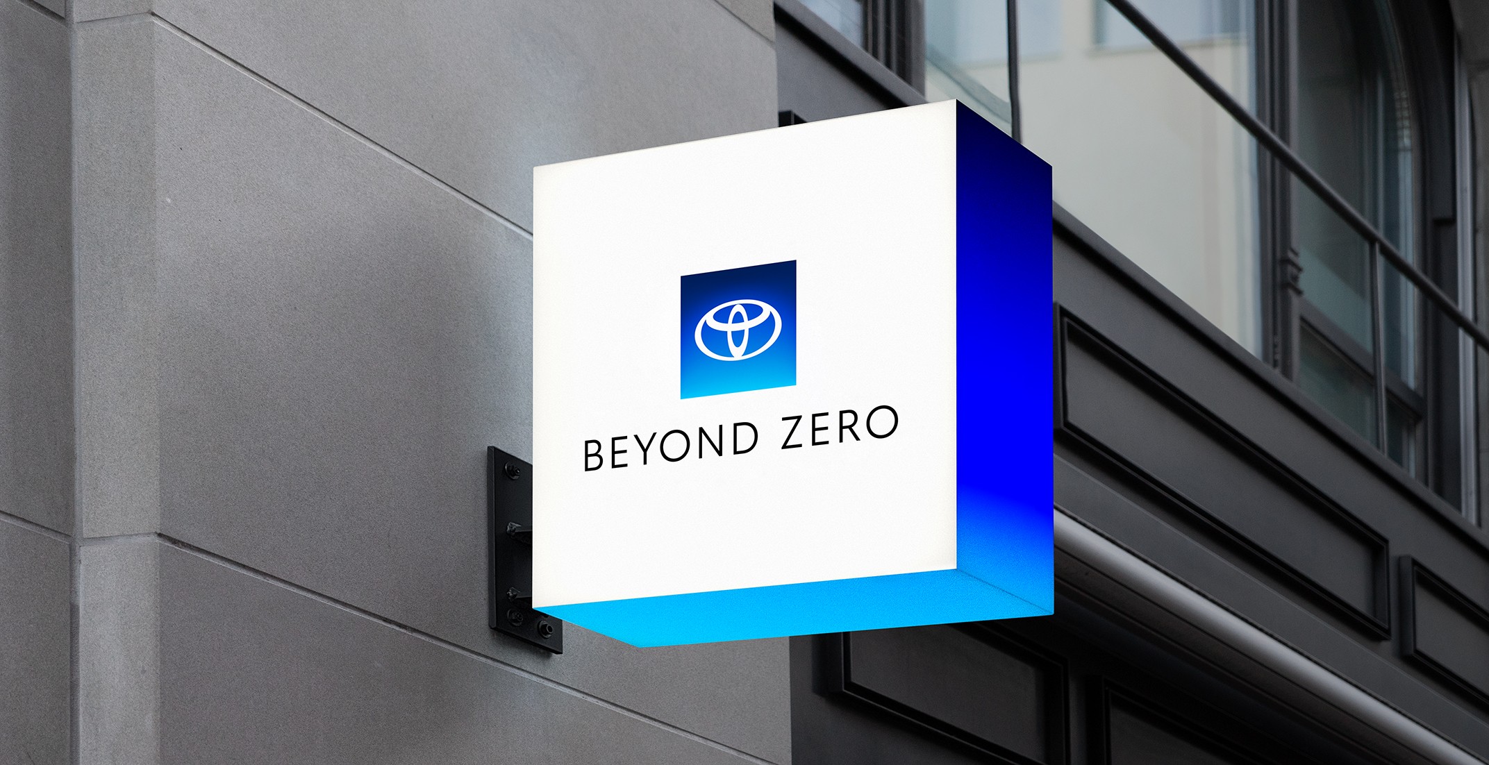 A lit sign on a building with the Beyond Zero logo and blue gradient.