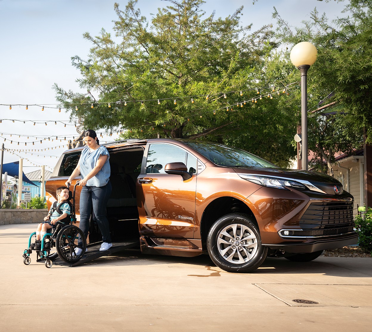 A mom assists her son as he gets out of a Toyota vehicle in his wheelchair.